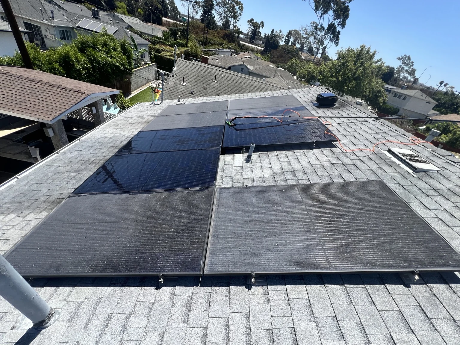 Rooftop solar panels partially cleaned, showing a before-and-after contrast